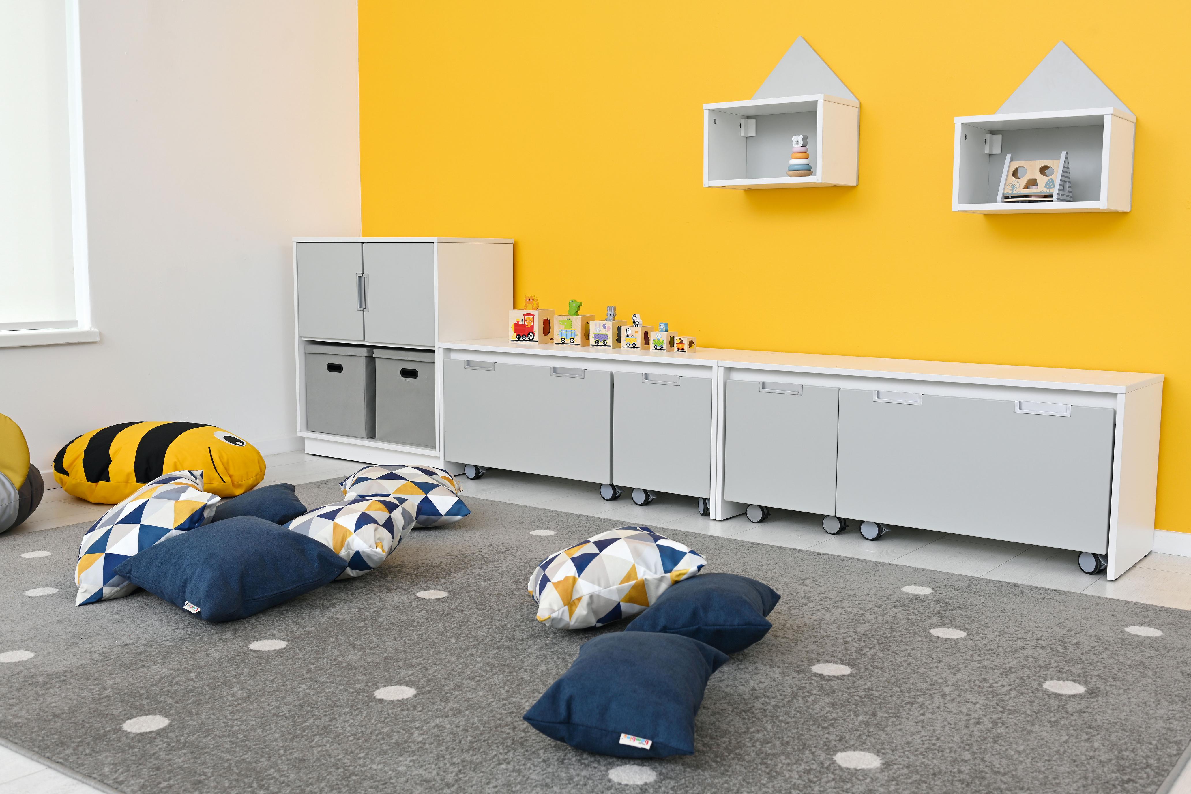 Bunte Kissen für Sitzlandschaft im Gruppenraum arrangiert.