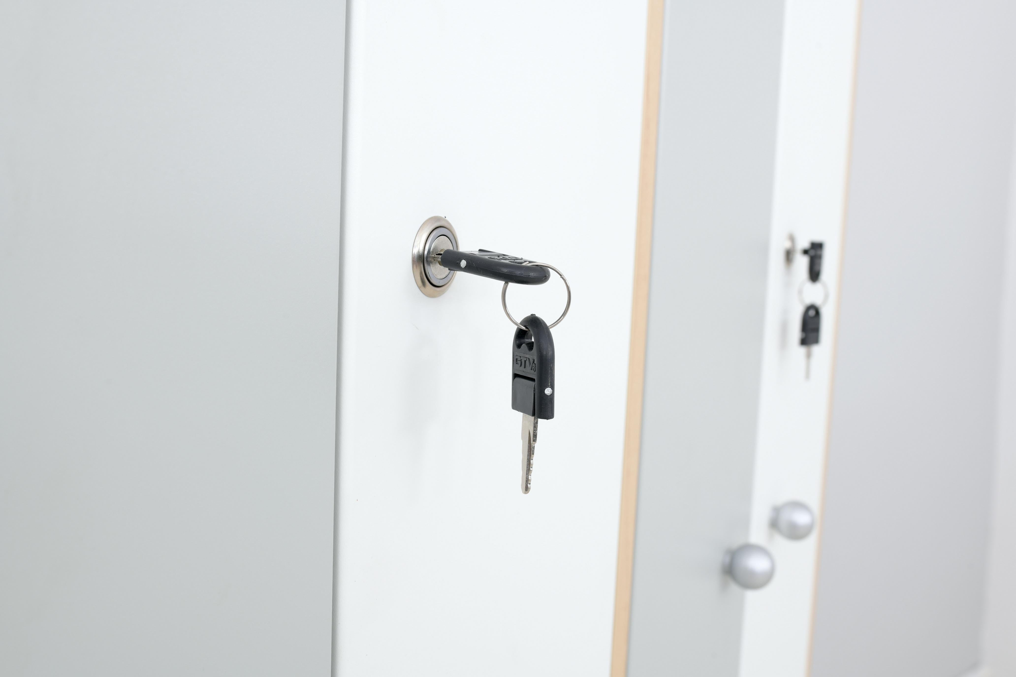 Weiß-graue Türen mit Schlüsseln eines Kleiderschranks.