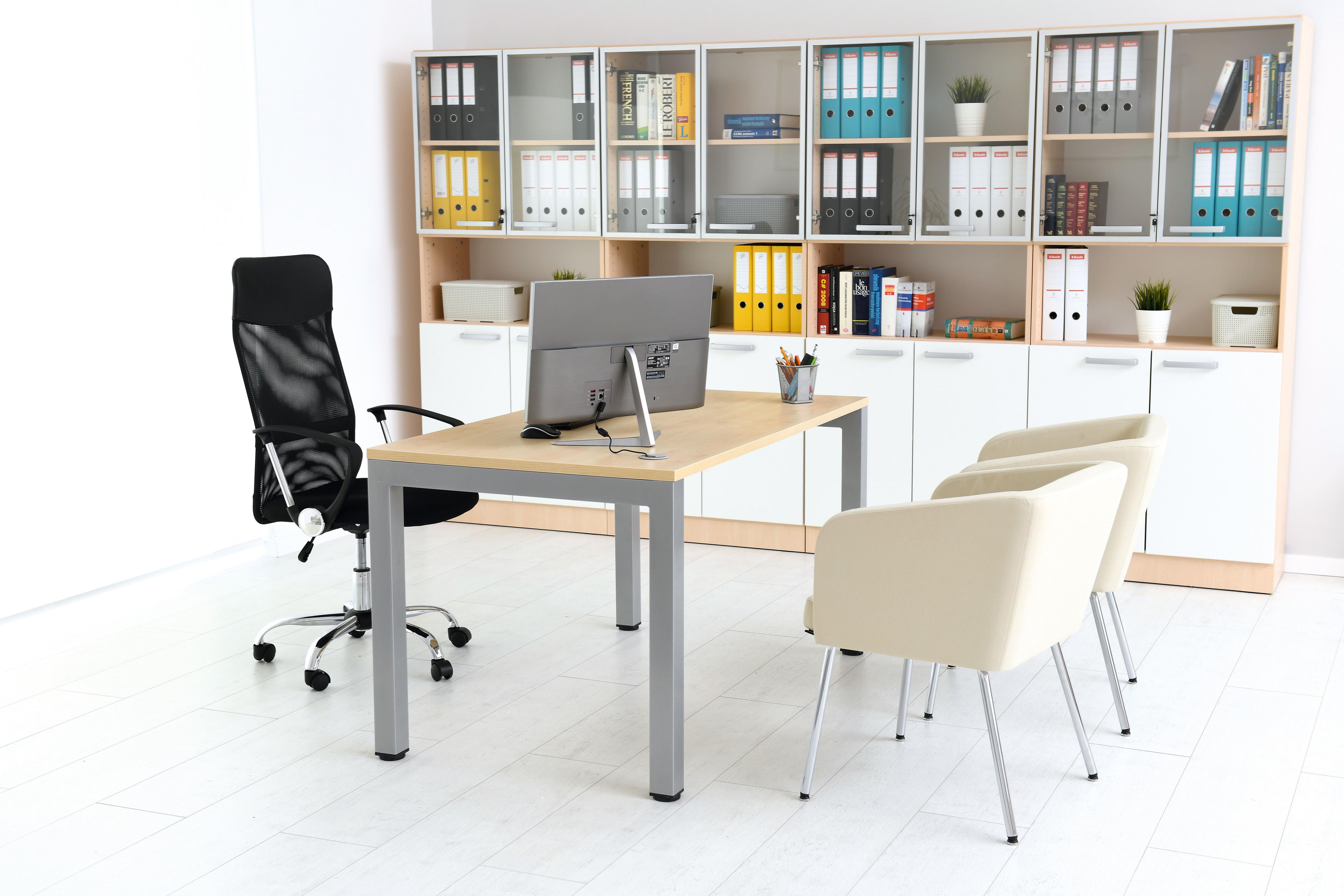 Moderner Raum mit Drehstuhl, Schreibtisch und Regalen.