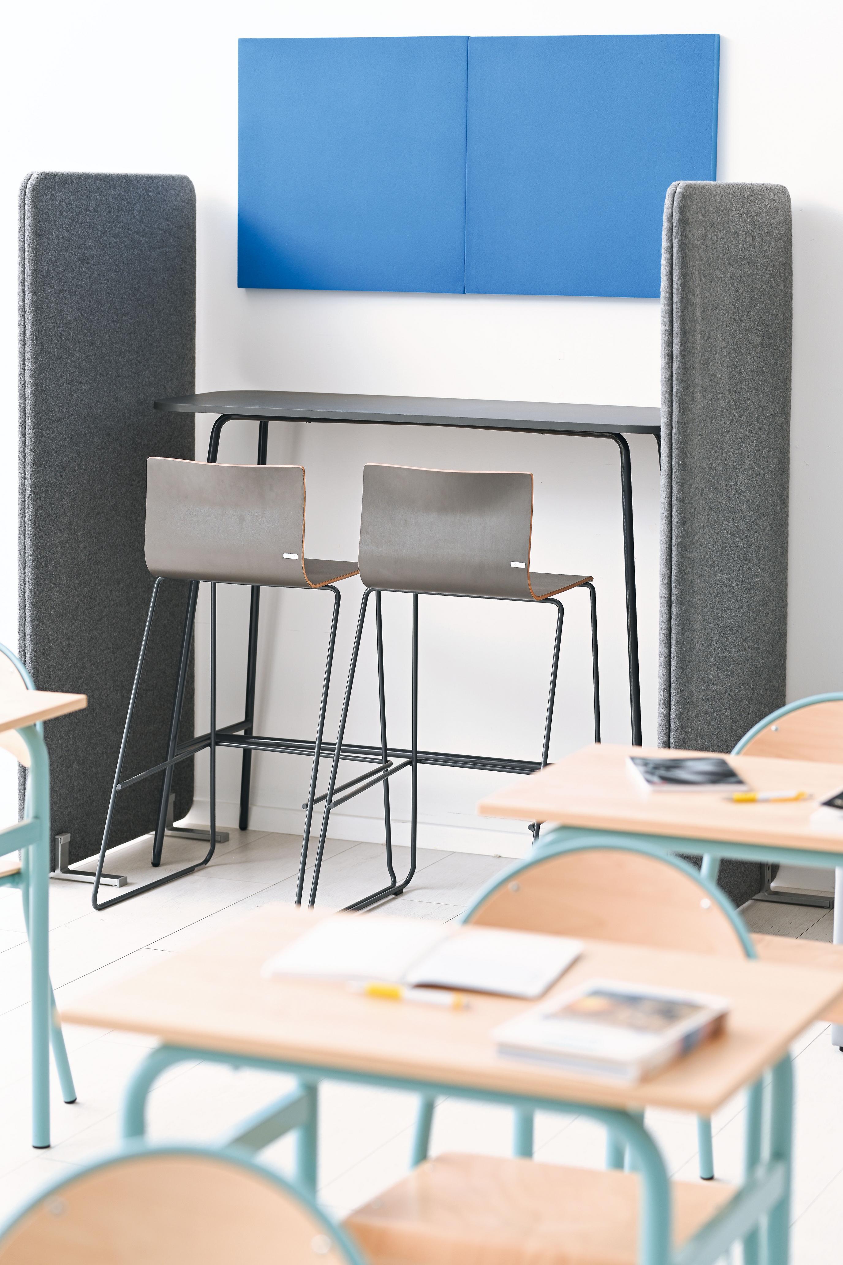 Hochtisch im modernen Klassenzimmer, umgeben von Stühlen.