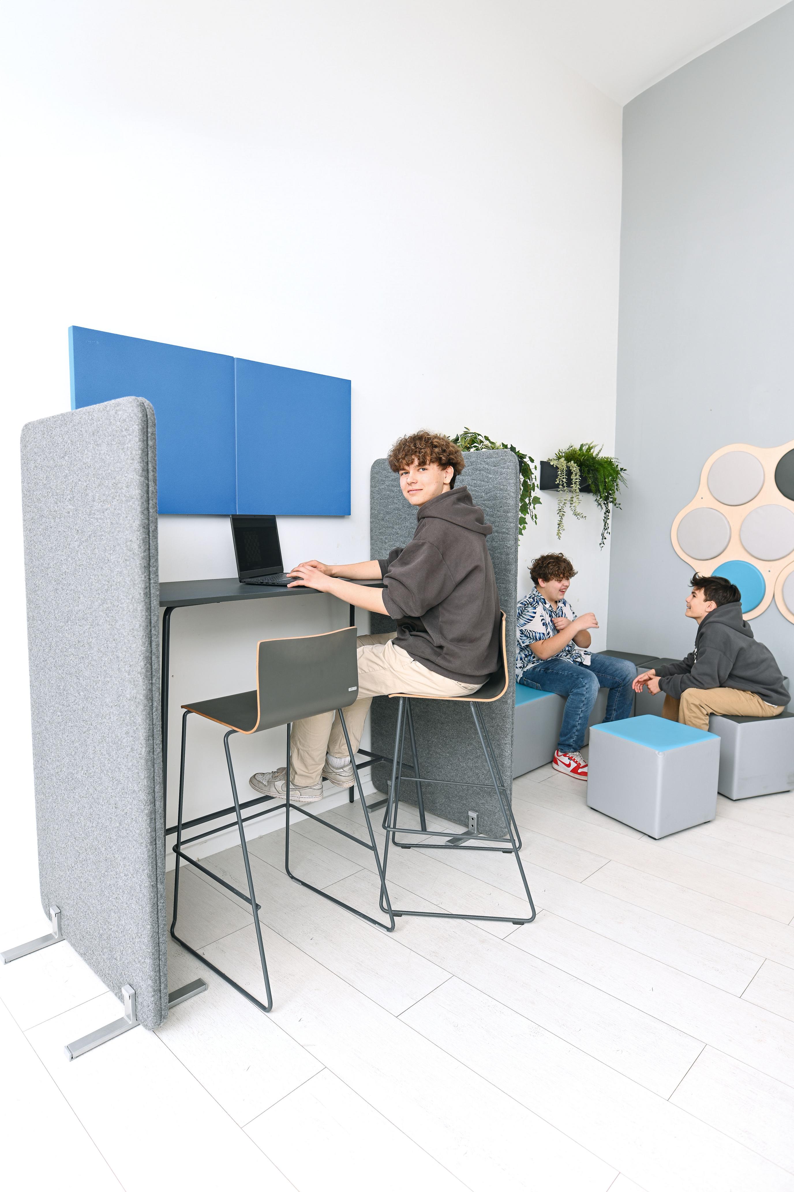 Hochtisch im modernen Gruppenraum mit Jugendlichen integriert.