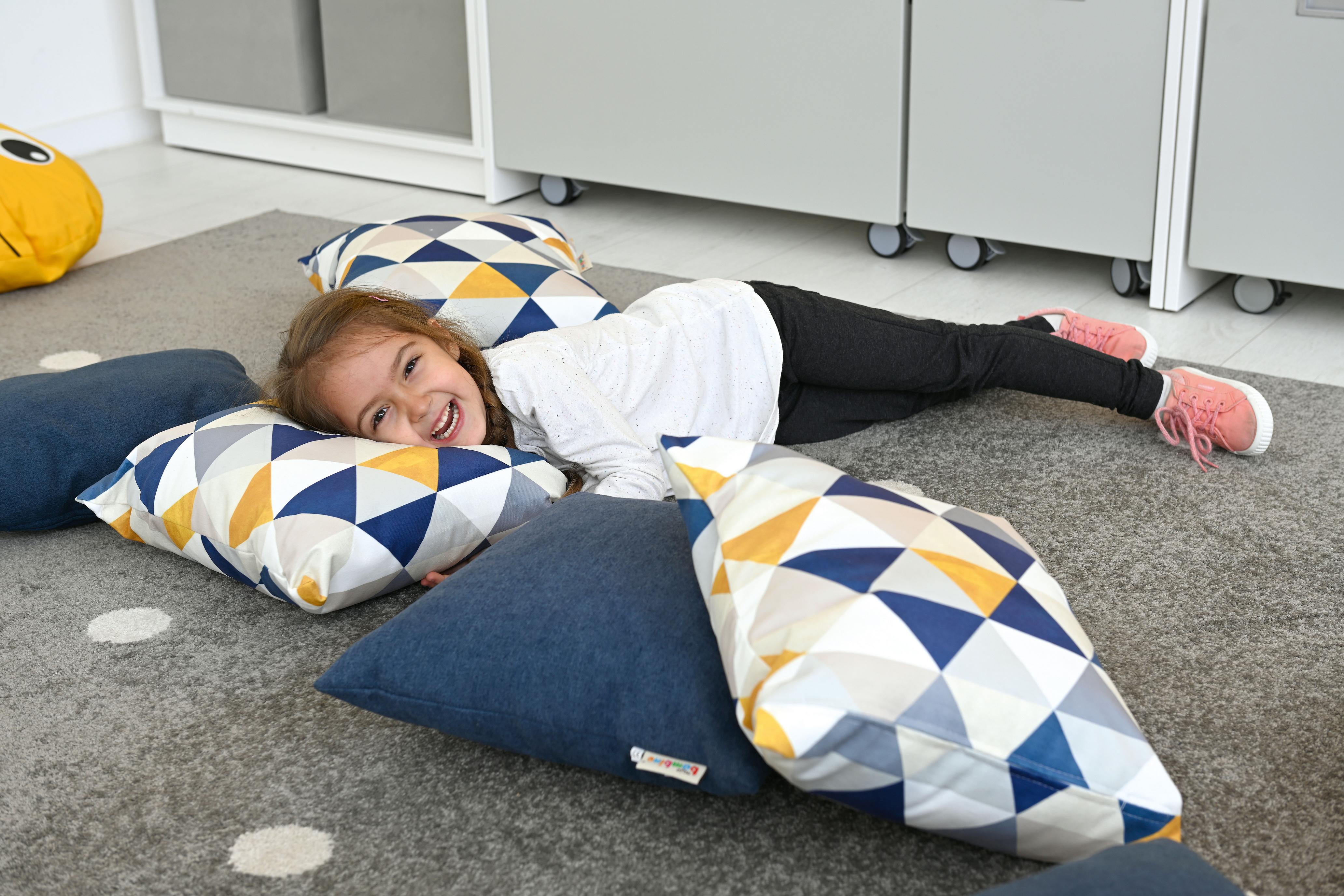 Kissen für Sitzlandschaft in fröhlichem Gruppenraum genutzt.