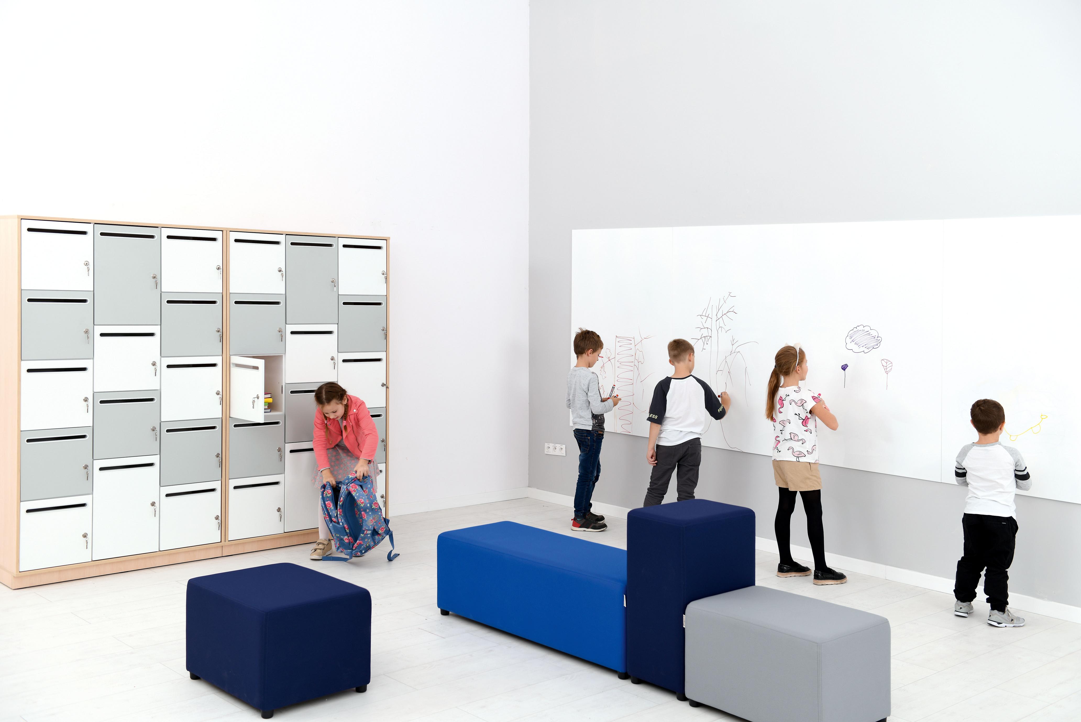 Kinder malen, Sitzlandschaften in modernem Schulraum.