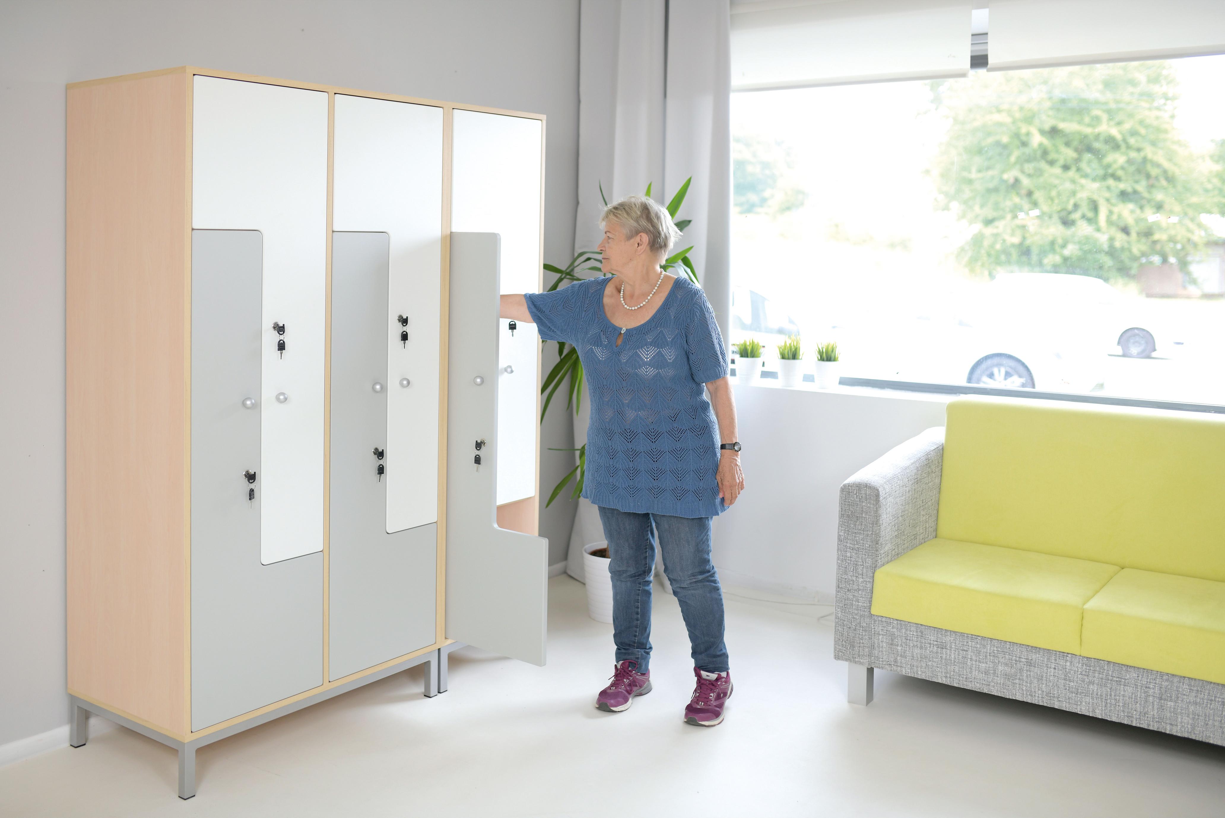 Kleiderschrank geöffnet im Raum mit Erzieherin.