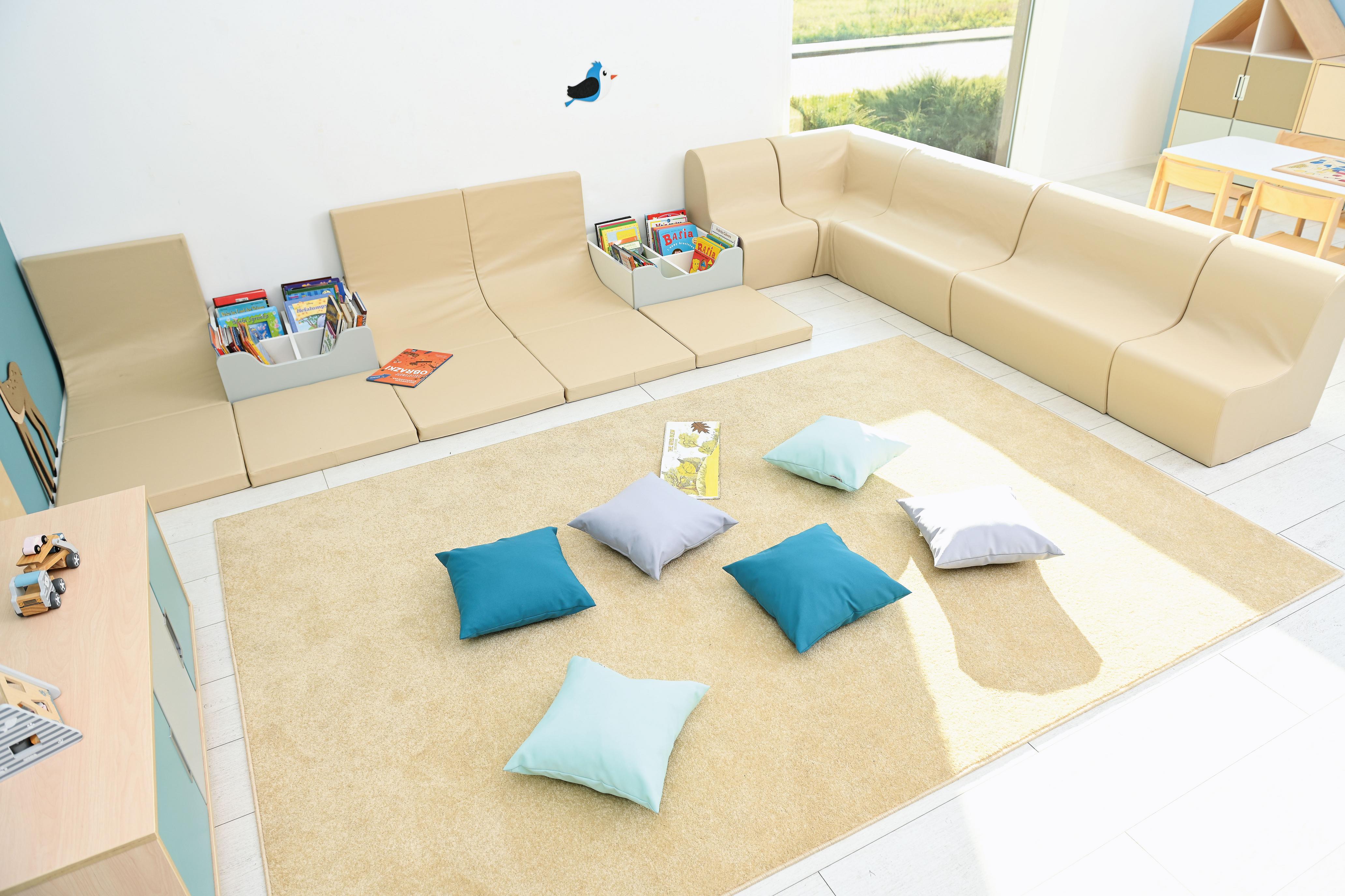 Bücherkiste und Kissen in gemütlicher Leseecke. - Produkt wird im Kindergarten oder Schule genutzt.