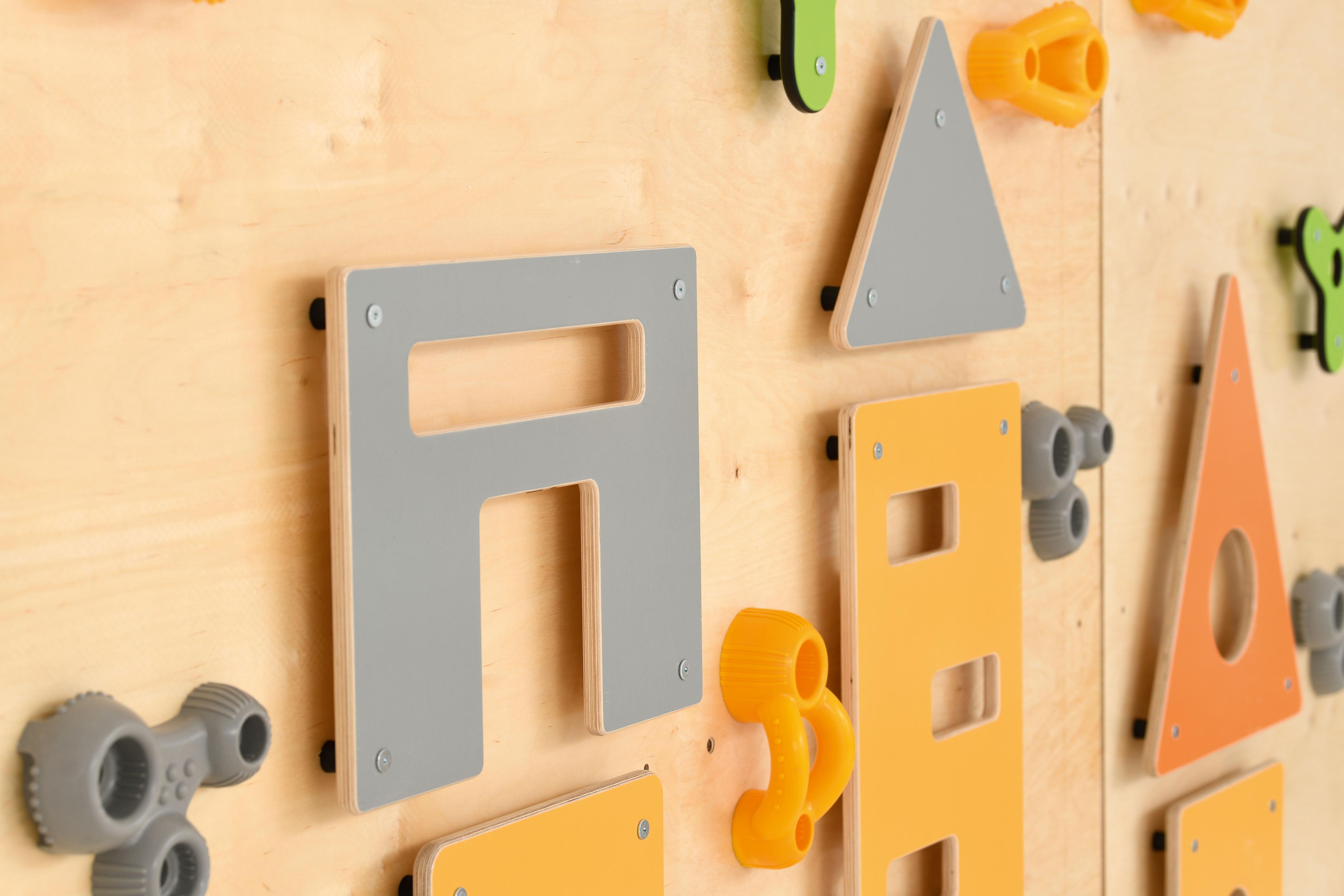 Bunte Kletterwand mit Formen, ideal für Kita.