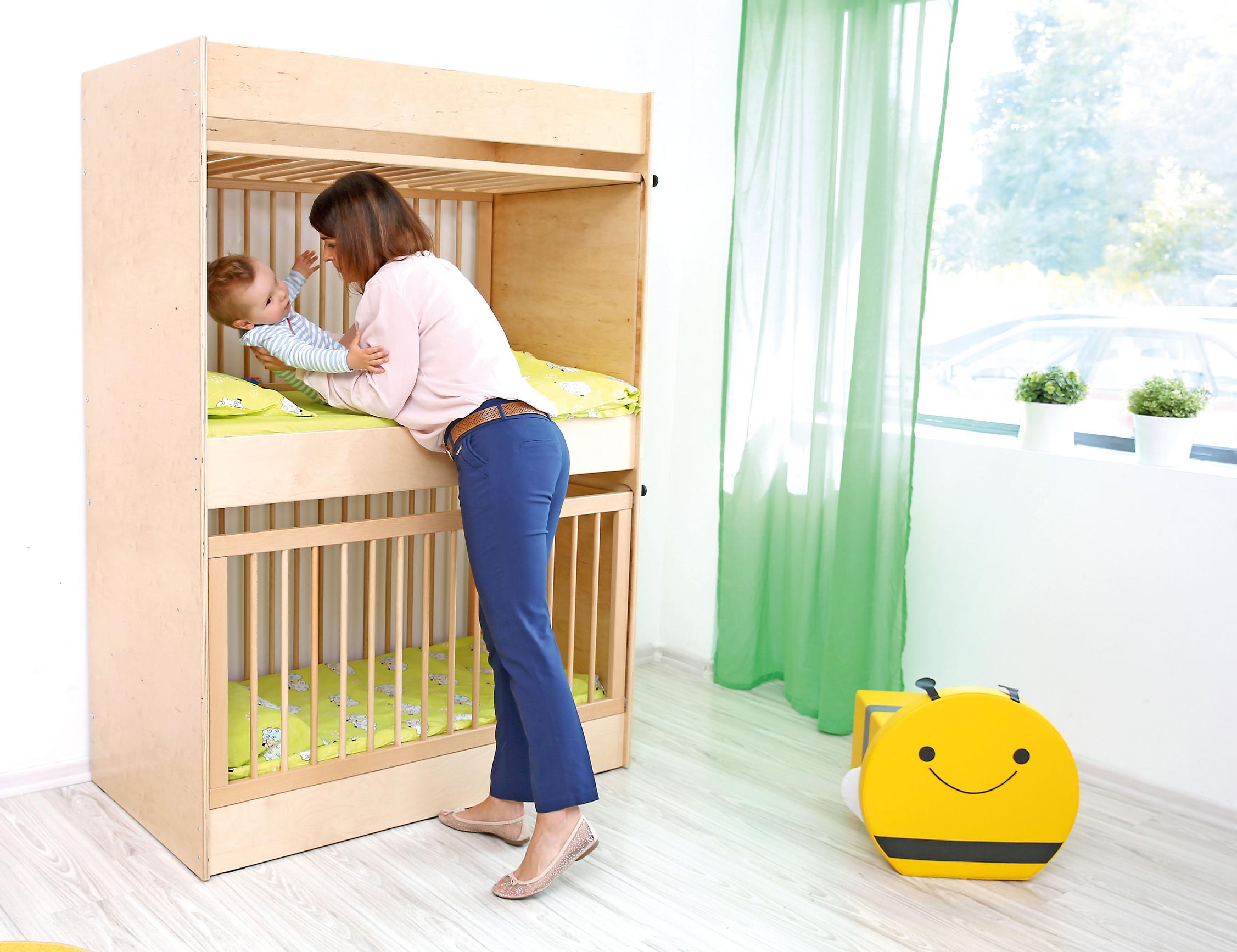 Etagen-Gitterbett in Kita mit Kind, Betreuerin fürsorglich. - Produkt wird im Kindergarten oder Schule genutzt.