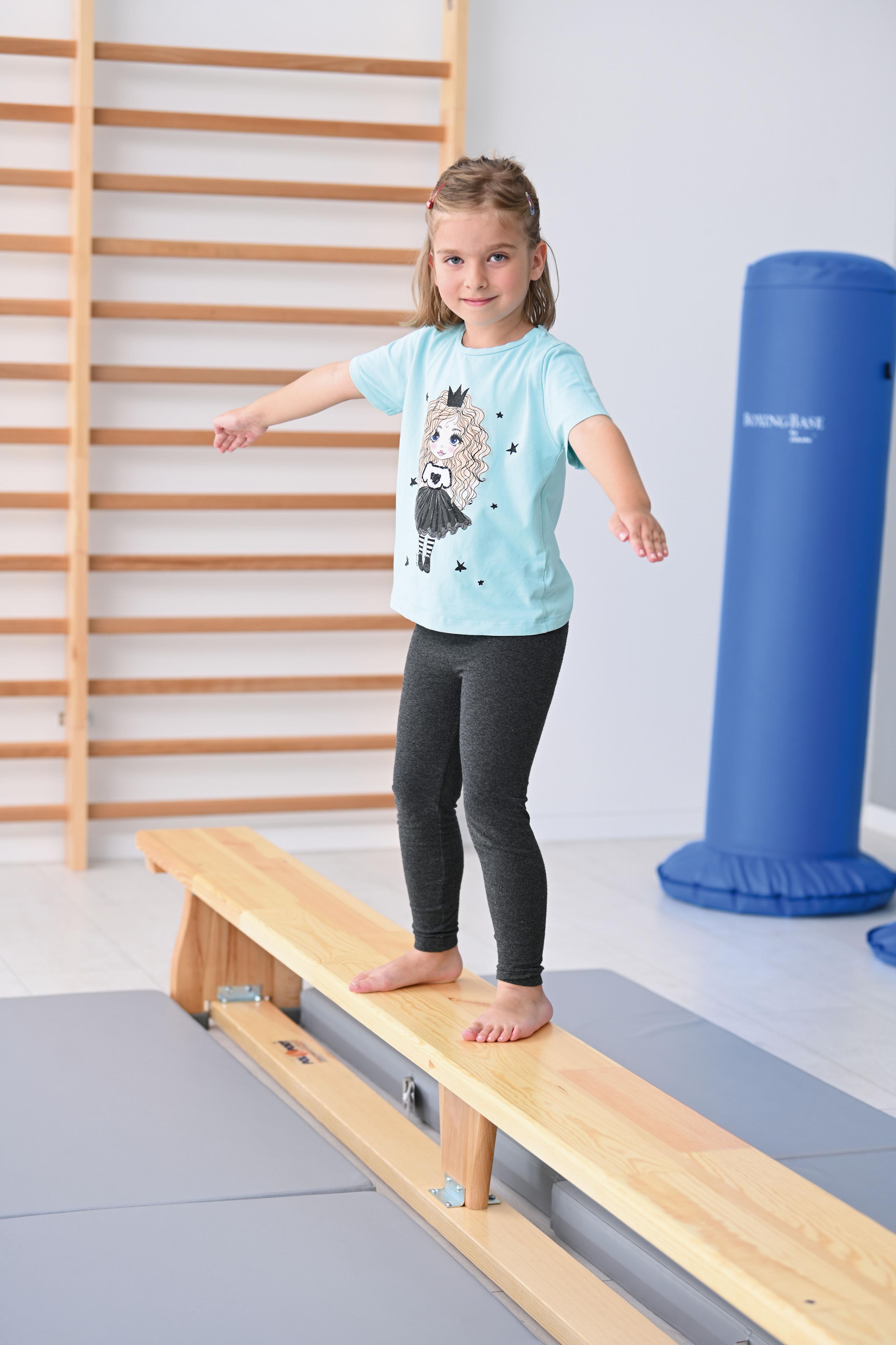 Kind balanciert auf einer Turnbank 3 m.