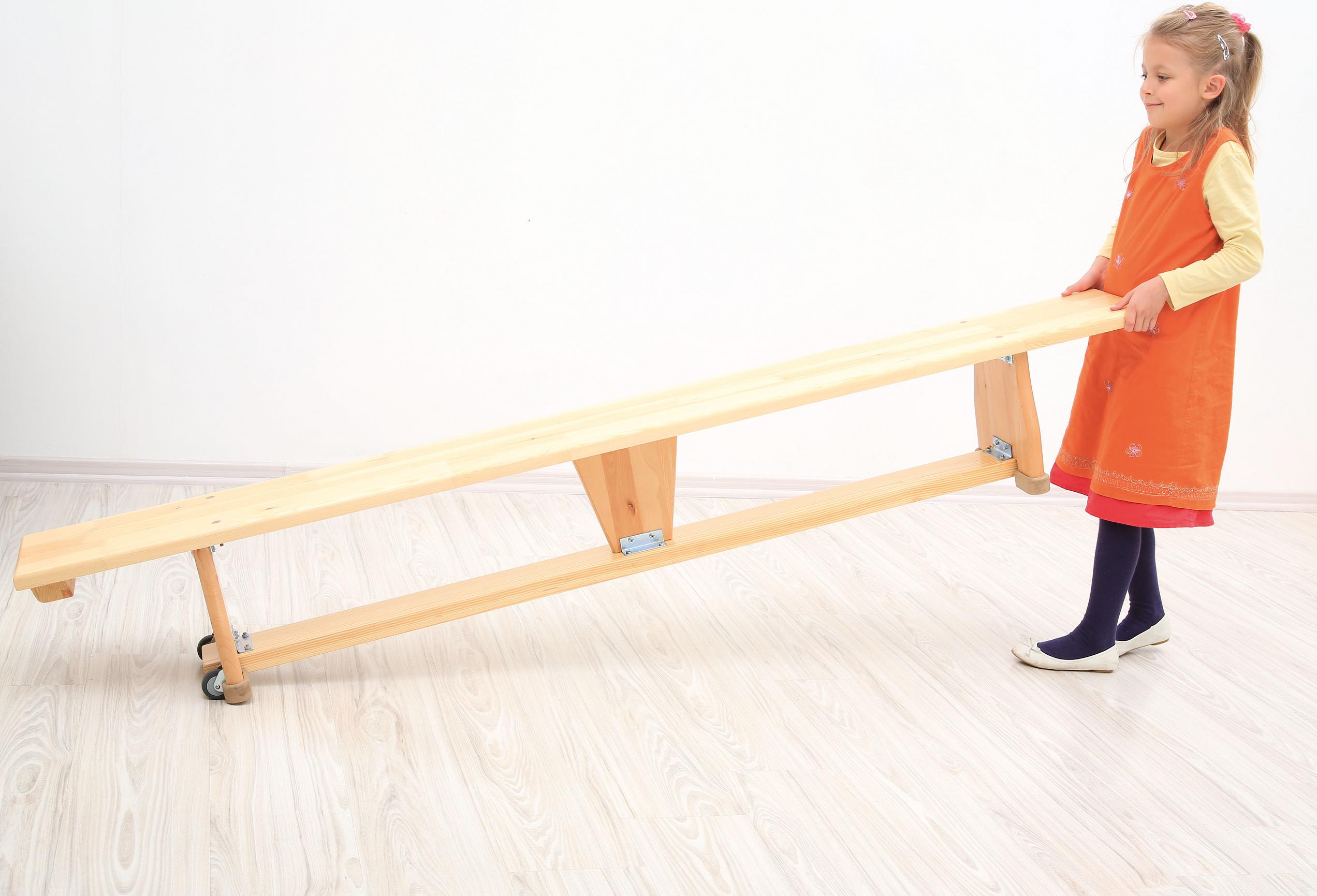 Kind schiebt die Turnbank auf Rollen, 2 m.