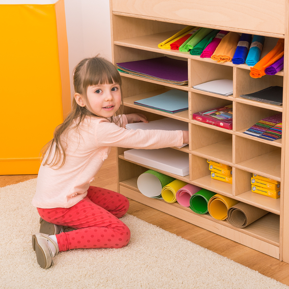 Kind im Kindergarten räumt Maltisch ein