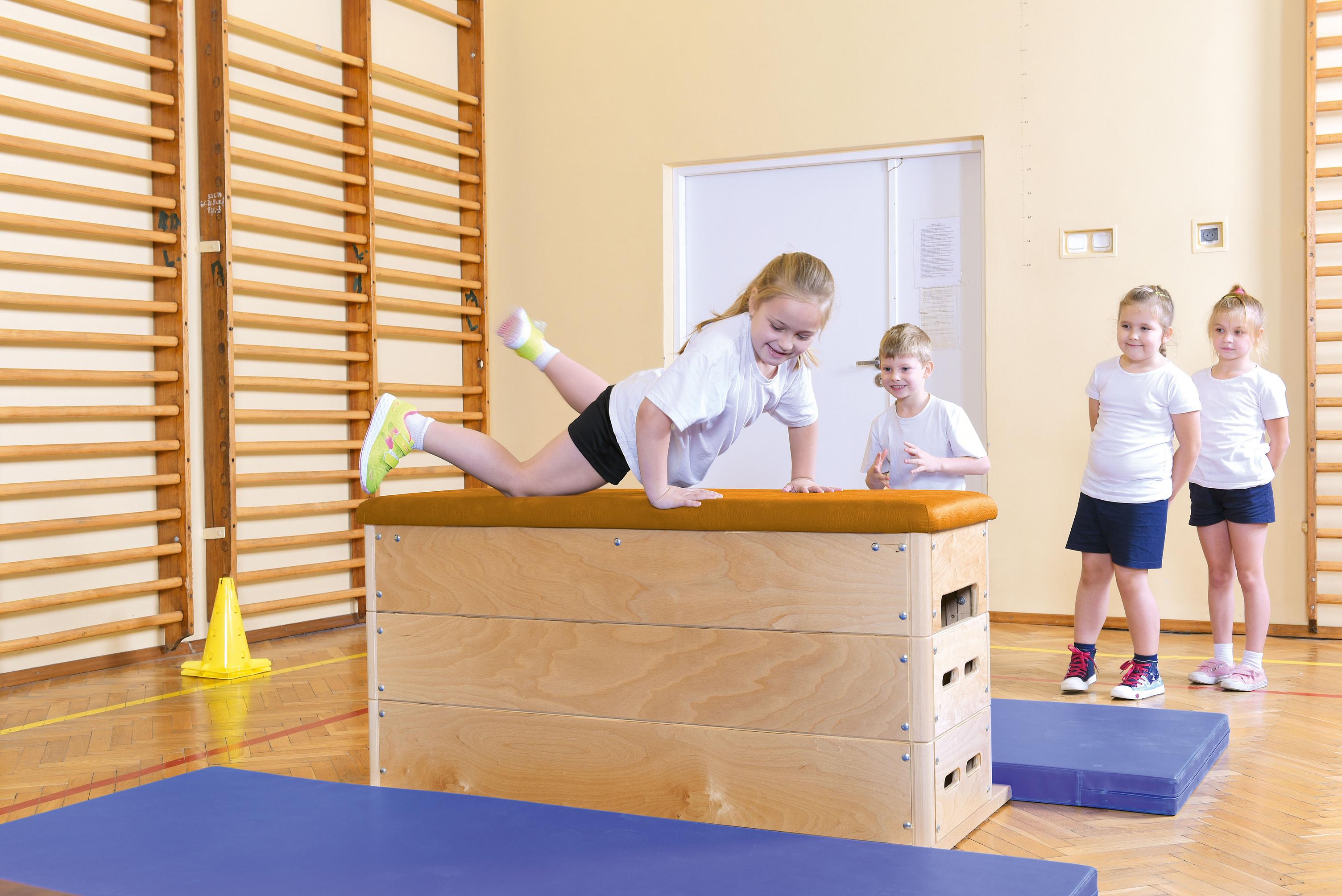 Kinder benutzen Sprungkasten für Turnhalle, 4-teilig.