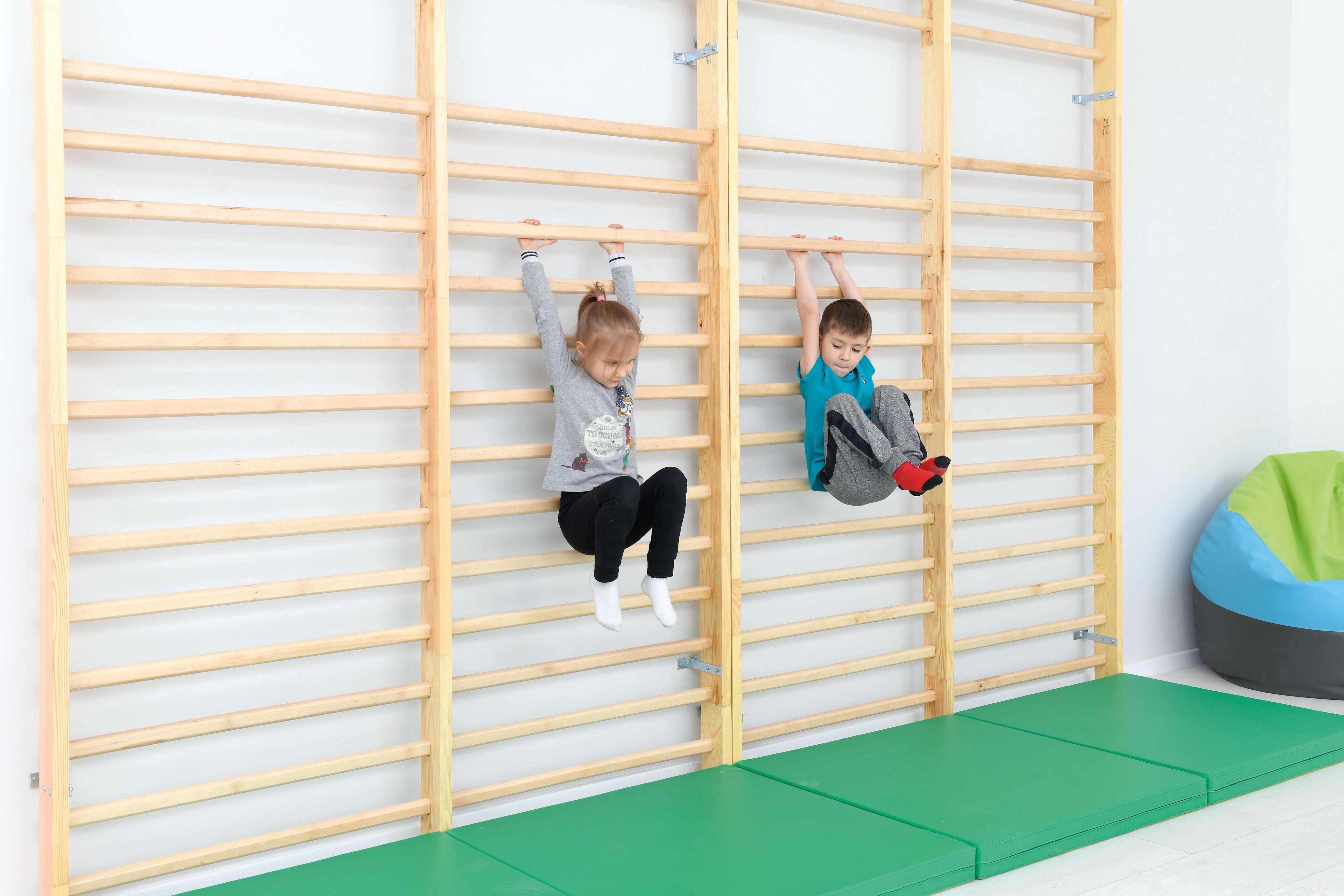 Kinder klettern auf doppelte Sprossenwand, 256 cm.