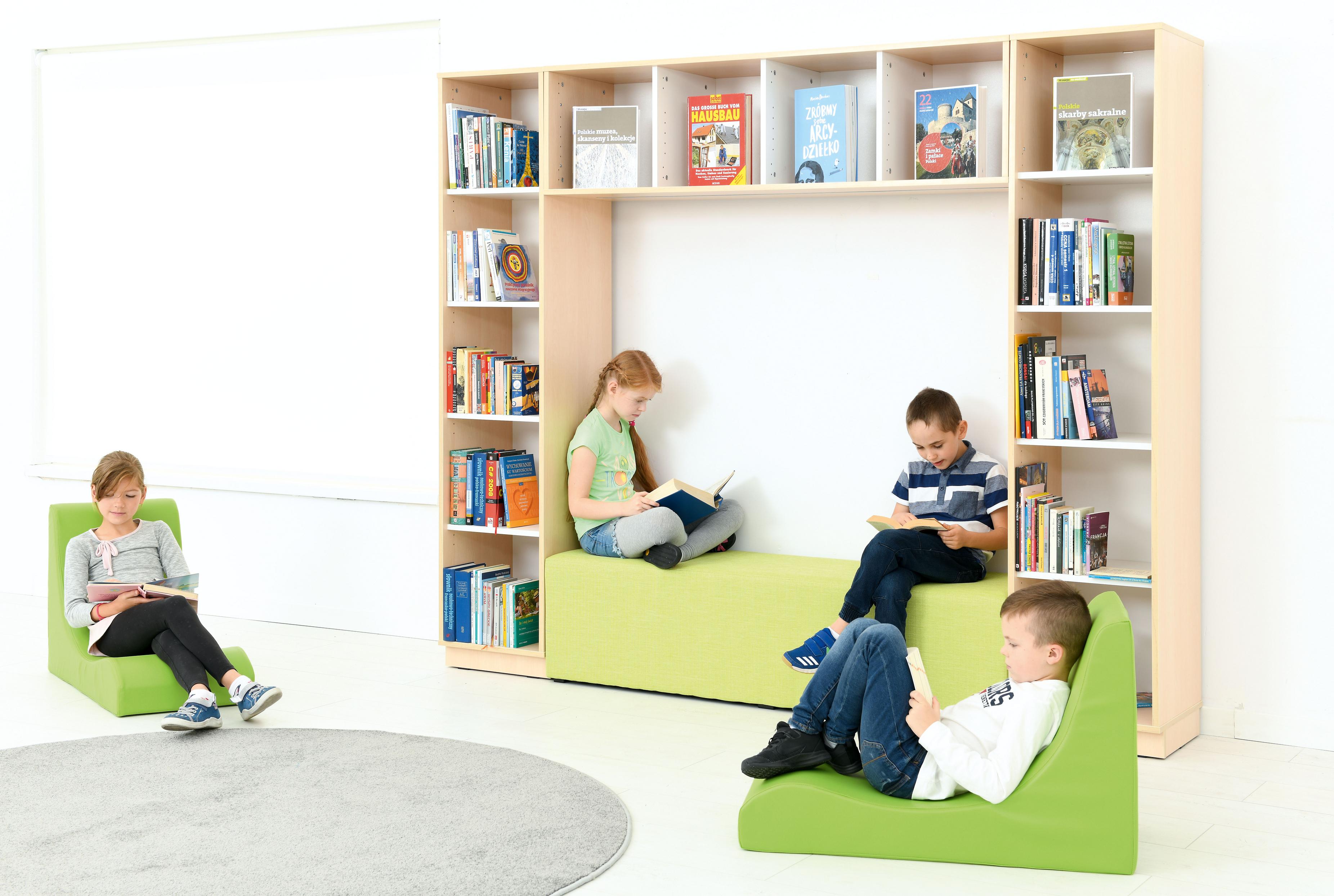 Kinder lesen in gemütlicher Bücherecke mit Bücherregal. - Produkt wird im Kindergarten oder Schule genutzt.