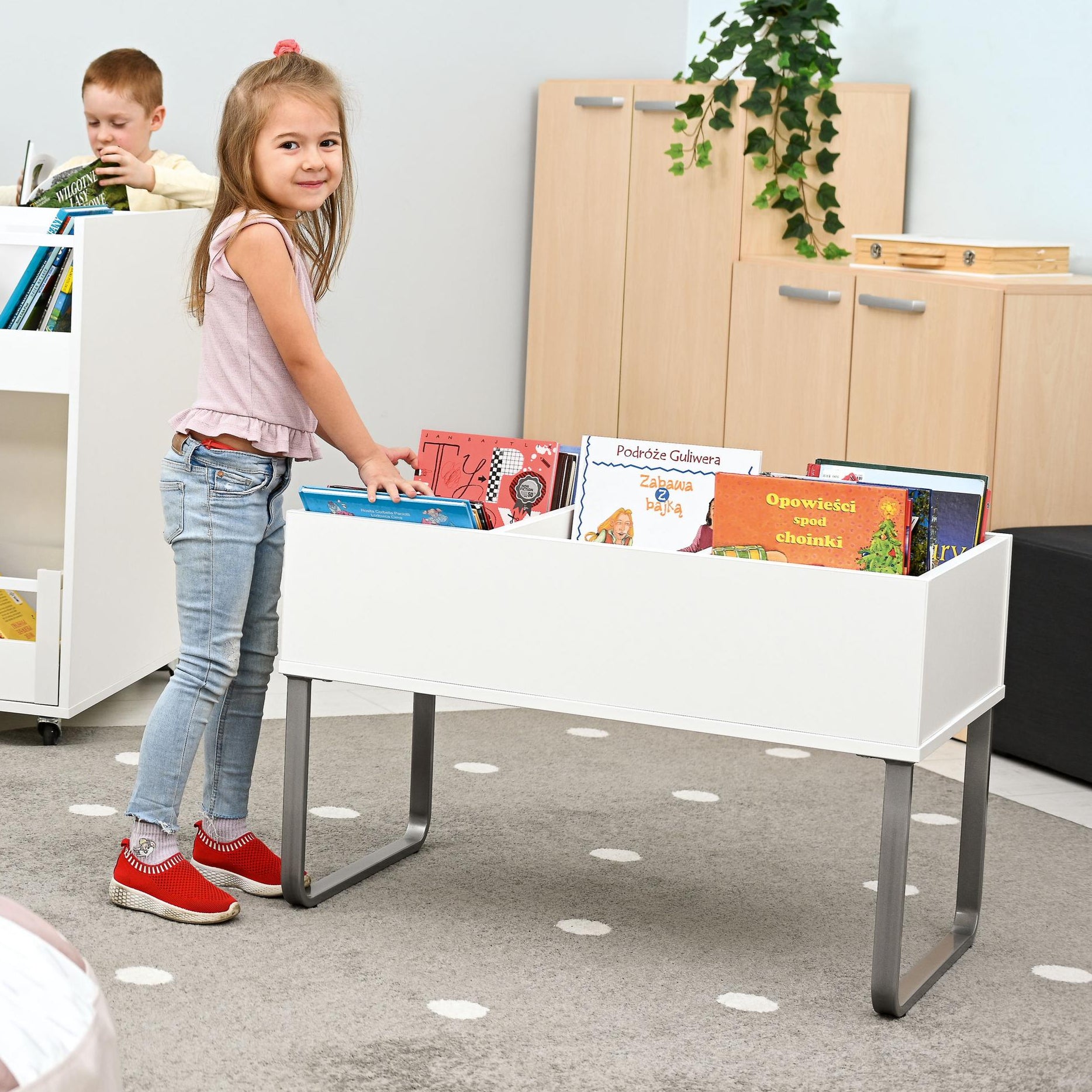 Kinder nutzen Bücherkiste mit Gestell im Gruppenraum. - Produkt wird im Kindergarten oder Schule genutzt.