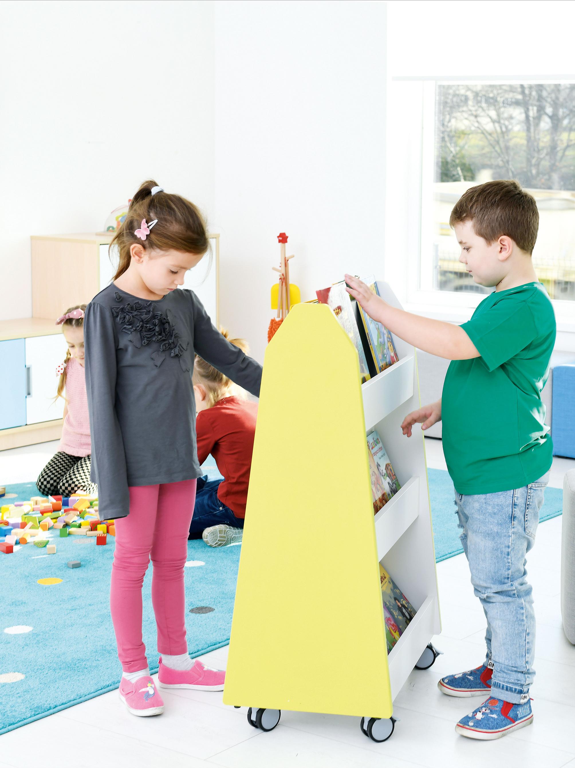 Kinder nutzen zweiseitiges Bücherregal im Gruppenraum. - Produkt wird im Kindergarten oder Schule genutzt.