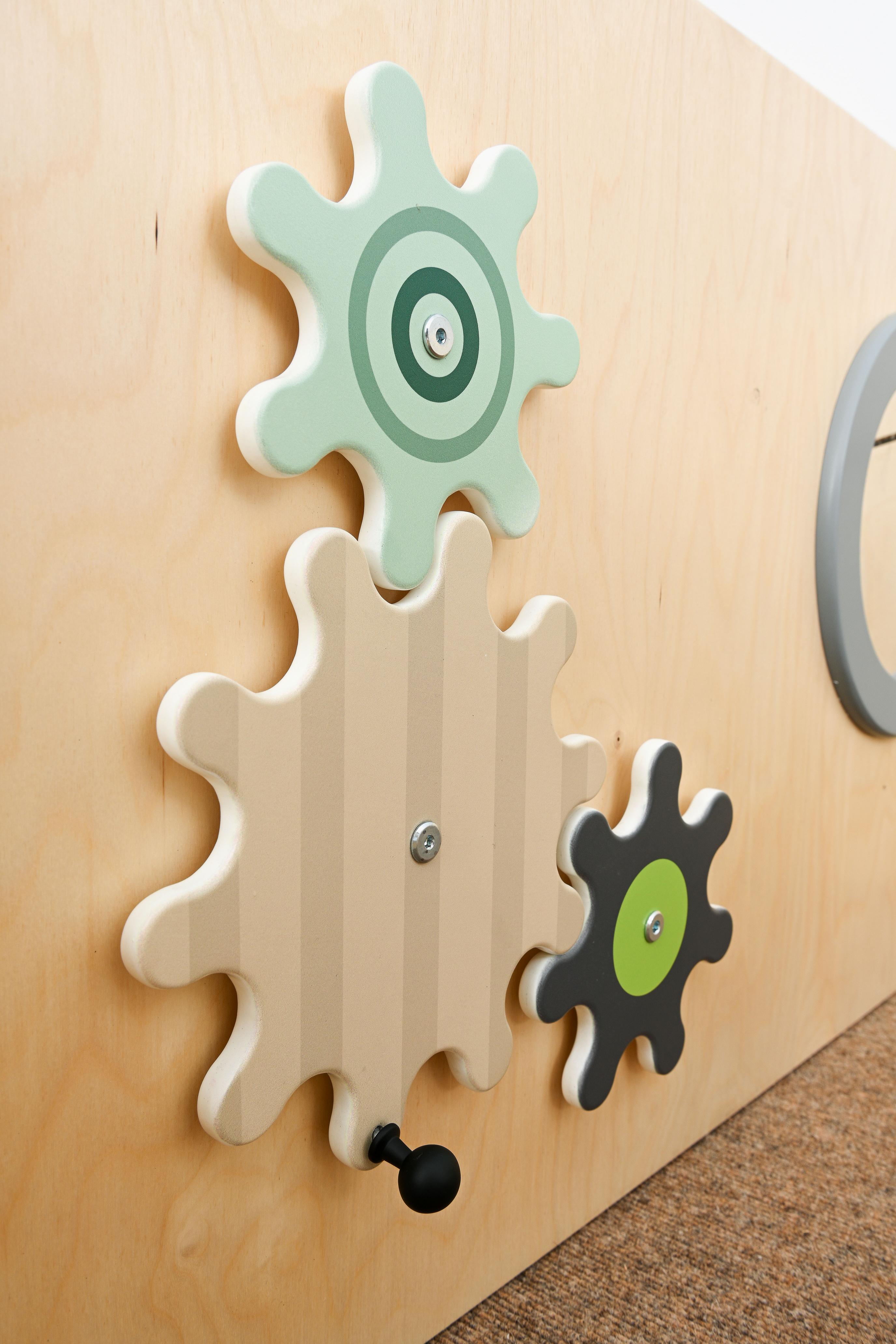 Sensorische Spielecke-Elemente mit Holz-Zahnrädern auf Hochebene.