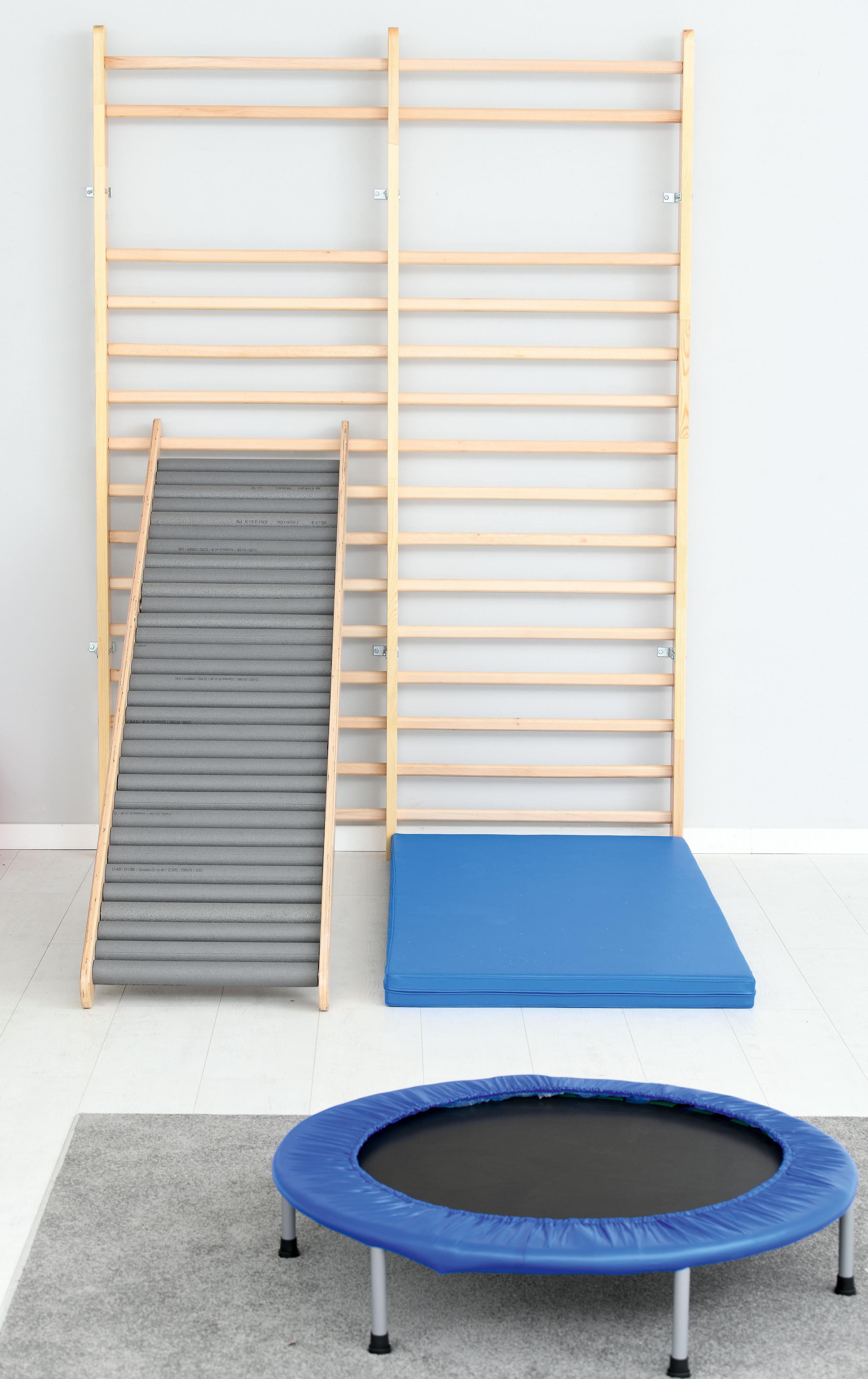 Sprossenwand mit Trampolin und Matte in Gruppenraum.
