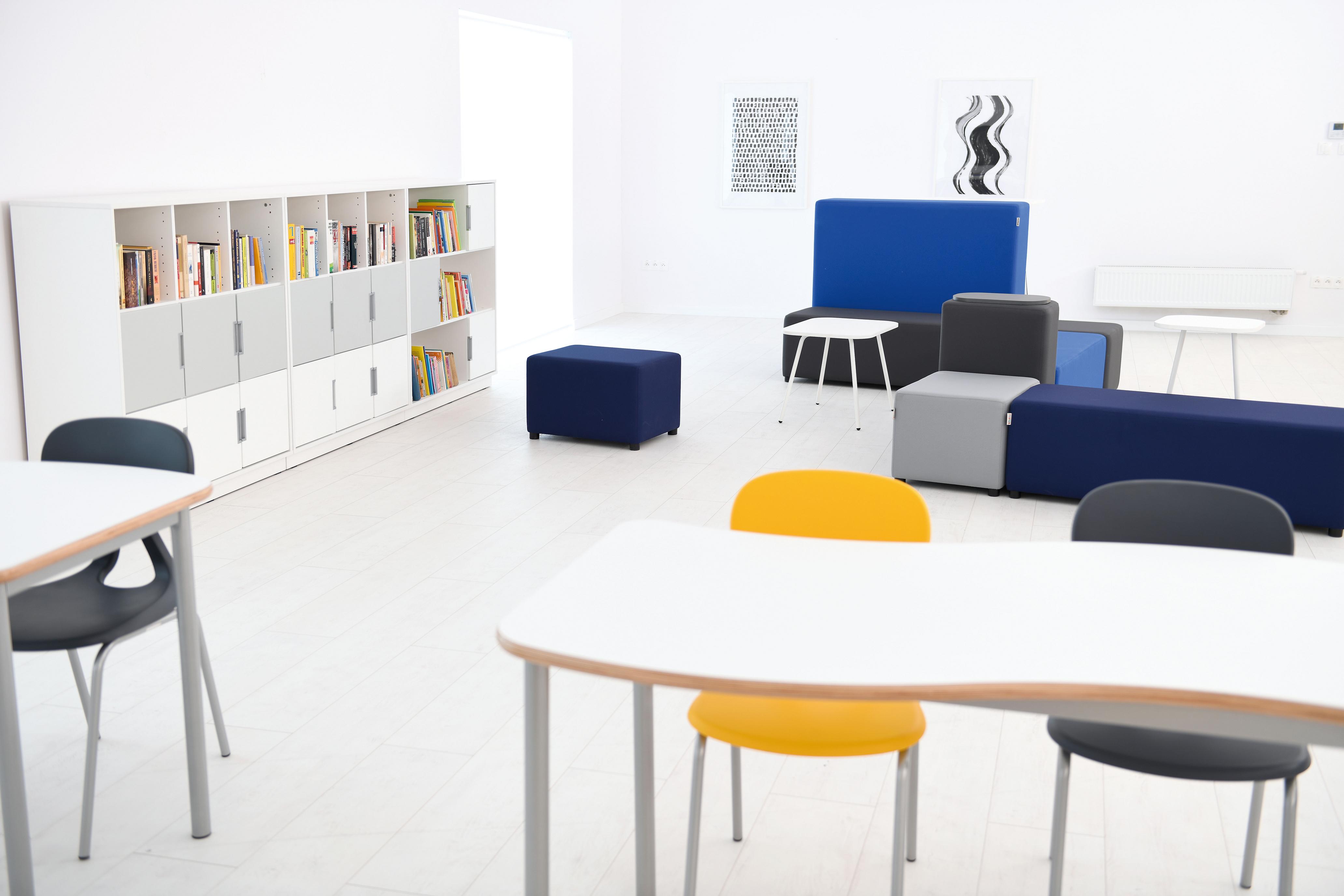 Modulare Sitzlandschaften und Loungemöbel im Schulraum platziert.