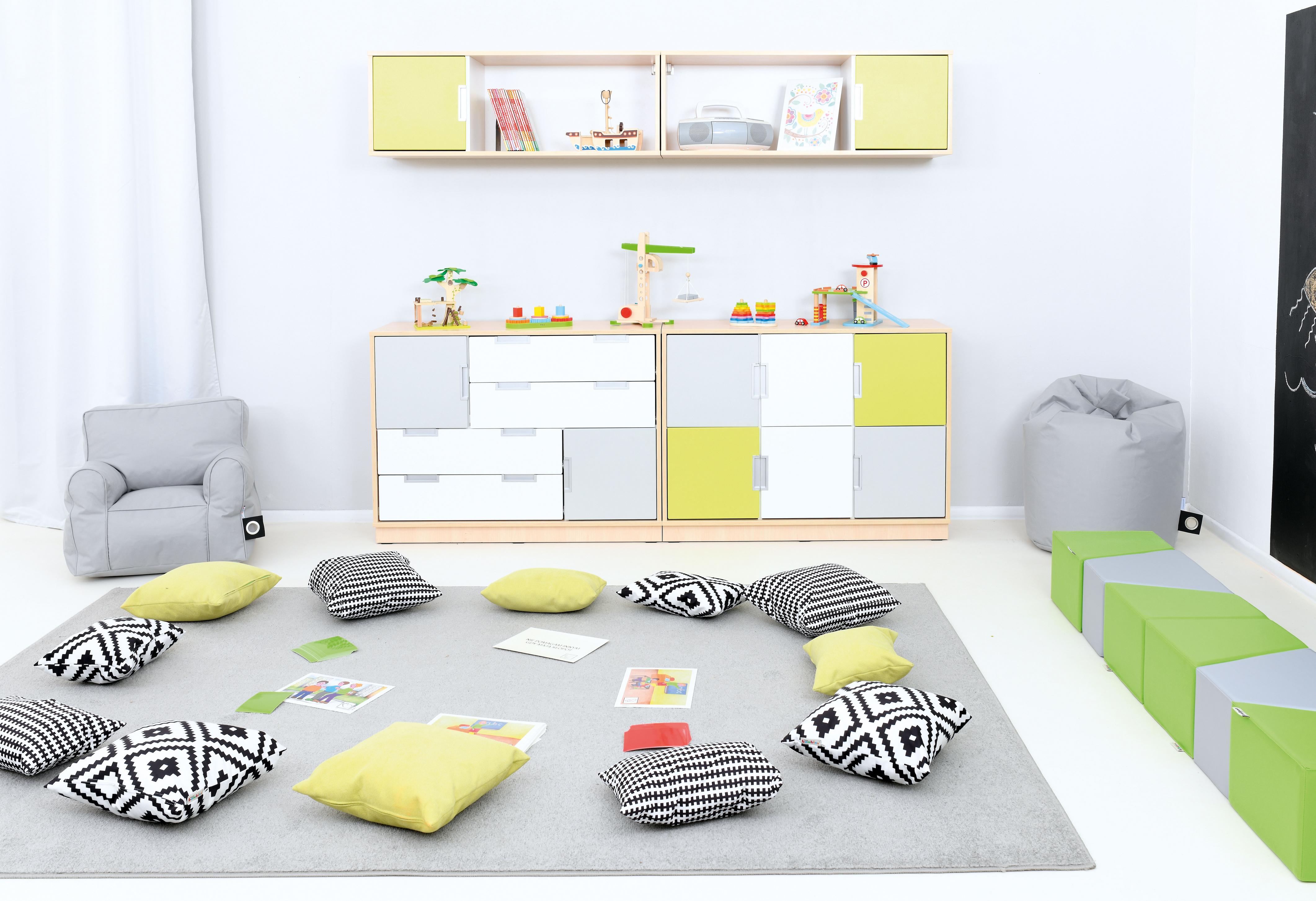 Kissen für Sitzlandschaft auf hellem Teppich angeordnet.