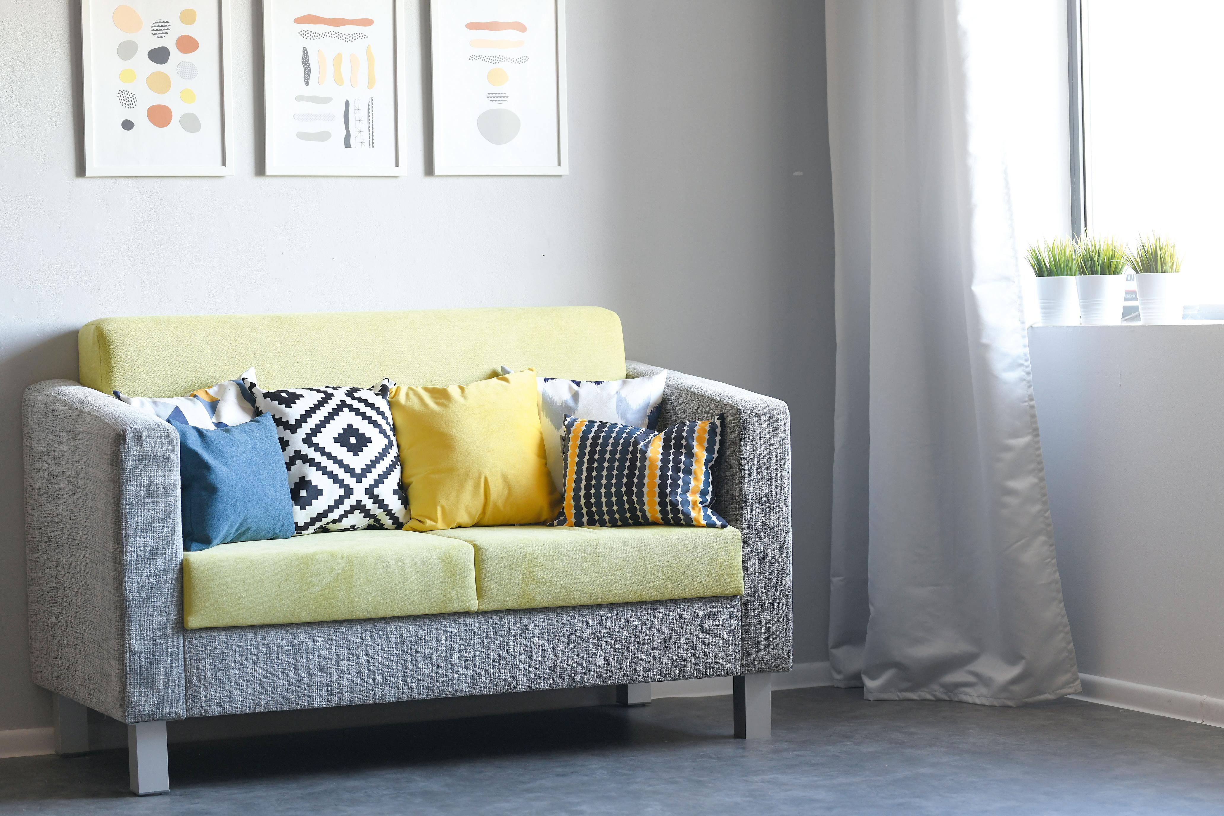 Bunte Kissen auf Sofa im modernen Gruppenraum.